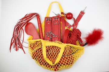 Yellow bag from sex shop with toys BDSM for adults on white background