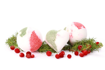 Bath bombs with green branches and berries isolated on a white background