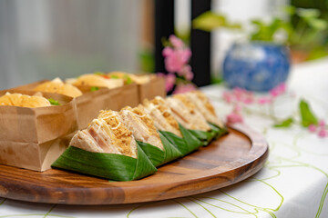 Close up to Dried shredded pork sandwiches that are arranged with blur hamburger behind it.