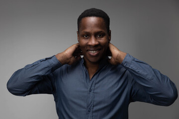 A handsome confident cheerful male entrepreneur has a wide smile, is happy to meet a colleague, and is dressed in a fashionable shirt isolated on a gray and white background