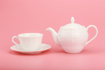 White porcelain tea set on a pink background 