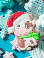 Christmas gingerbread in glaze in the form of a bull. Christmas symbols, on table with New Year's decor.