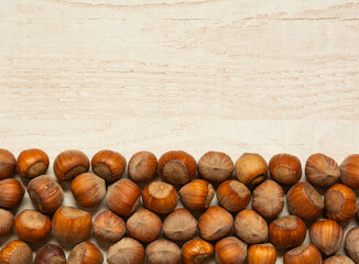 brown nuts with shells on wood background.