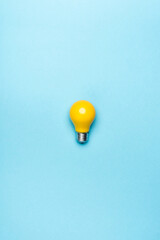 top view yellow light bulb on blue 
