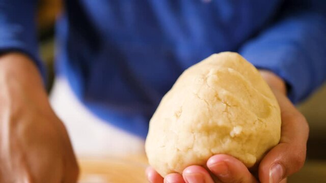 close up hands kneading a dough into a ball
