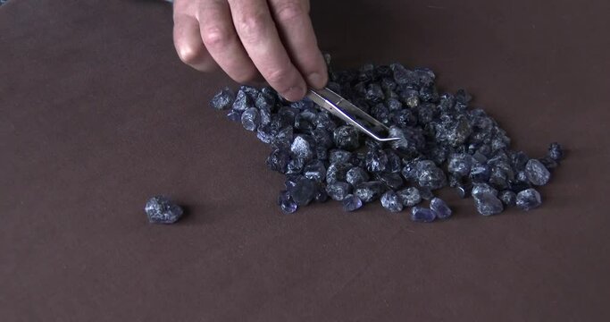 A jeweler sorting through rough Ilolite gems before cutting and faceting