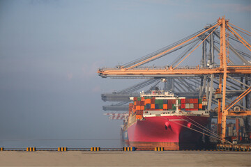 Pink ship container cargo entering commercial port, Logistics and transportation of container cargo pink ship and cargo logistic import export background and transport sunset twilight