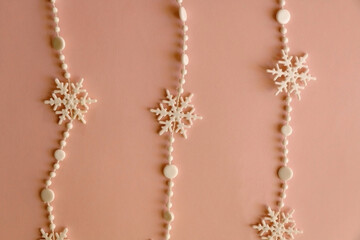 Snowflake garland on pink background. Top view.