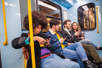 Group of four multiethnic people traveling subway using smartphone - Group of friends multiracial talking together using smartphone