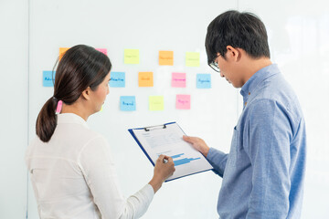 Fototapeta premium business teamwork in meeting and adhesive stick note on mirror board discussting with team in office room for collecting some idea brainstorming plan.