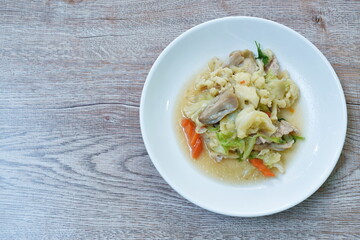 stir fried mixed vegetable cauliflower baby corn cabbage with carrot couple straw mushroom and pork on plate
