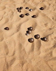 Fototapeta na wymiar Petanque game. Iron balls on yellow sand. Sports and recreation on the coast