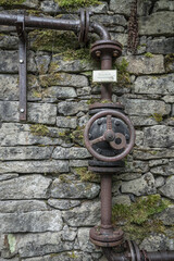 vintage pipework on a weathered stone wall