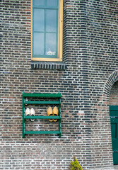 Traditional wooden dutch shoes outside a windmill.