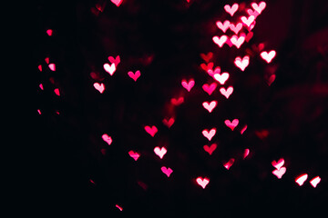 Fototapeta na wymiar Defocused bokeh lights in shape of pink and red hearts.