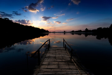 Fototapeta premium Bamboo bridge By the lake at sunset in thailand