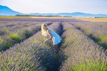Jeune fille blonde dans le champ de lavandes en Provence en été, France