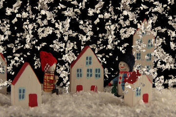 Snowmen walking in night city in heavy snow flurry. Christmas concept. Horizontal image
