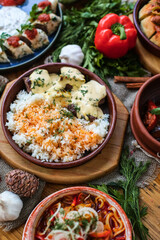 Muslim Ramadan iftar family dinner. Flat-lay of people feasting over table with Middle East food. Dates, dolma, kebab, flatbread, pide, borek, sweet, salad, top view. Ramazan fasting Turkish cuisine.