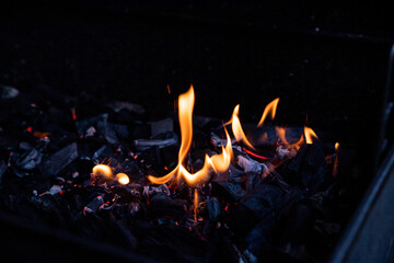 Flaming Empty Hot Barbecue Charcoal Grill With Glowing Coals On Black Background.Flame dance, barbecue on an open fire.burning wood. fireplace. BBQ preparation