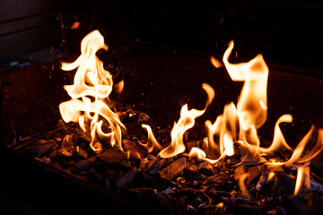 Flaming Empty Hot Barbecue Charcoal Grill With Glowing Coals On Black Background.Flame dance, barbecue on an open fire.burning wood. fireplace. BBQ preparation