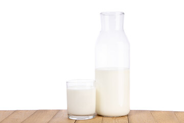 A bottle of milk and glass of milk on a wooden table, isolated on white