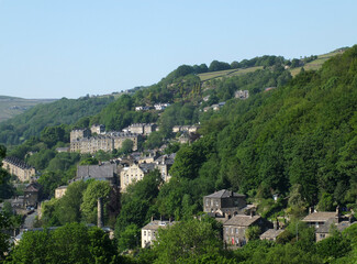 view of the streets and houses in hebden bridge in west yorkshire in summer surrounded by trees