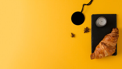 Desayuno con croissant en fondo amarillo, concepto banner para paginas web