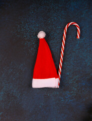 Christmas dark background. Red cap of Santa Claus.