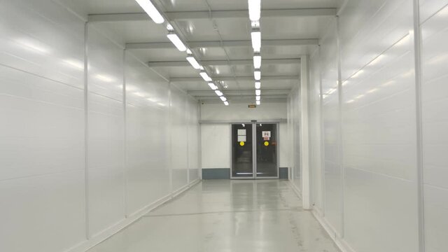 Interior of empty hospital hallway with entrance door