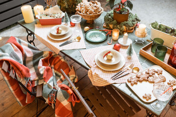 Beautifully decorated dinner table on the terrace outdoors during the New Year holidays