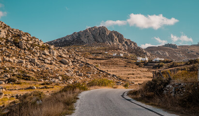 A view of road and rocky landscapes in the foothills of Mount Exomvourgo on the island of Tinos, Cyclades, Greece