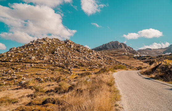 A road, rocky landscapes, and unique geological formations in the foothills of Mount Exomvourgo on the island of Tinos, Cyclades, Greece