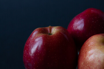Red, juicy apples isolated on a black background. Dark food photography. Side view