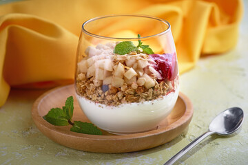 Greek yogurt with mango on light stone background. Breakfast food concept, menu