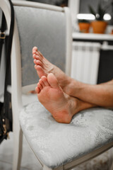 male feet on a chair at home