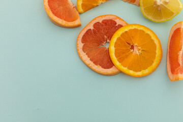 Slices of grapefruit, orange and lemon on blue background