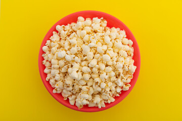 High angle view of popcorn in red bowl on yellow background