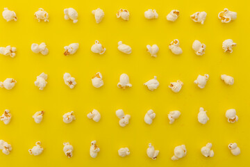 High angle view of popcorn in multiple rows on yellow background