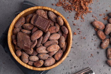 Flatlay Cocoa beans, cocoa powder, raw chocolate on a gray background. The concept of healthy eating.