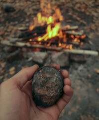 hand holding a burning potato