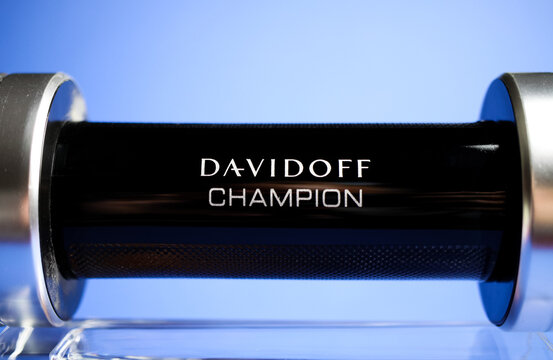Viersen, Germany - May 9. 2020: Close up of isolated Davidoff champion men perfume flacon in shape of dumbbell on glass, blue background