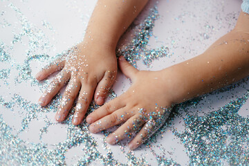 small children's hands in glitter sequins . Christmas new year holidays.