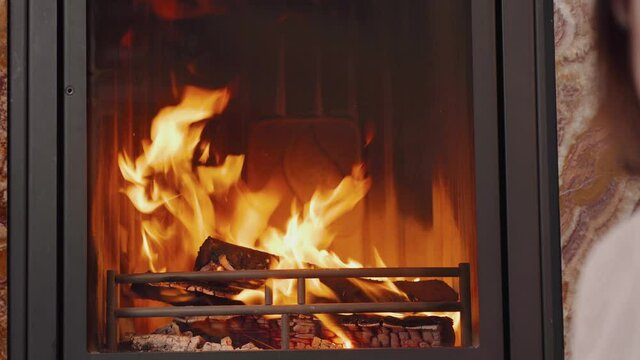 Girl with a bouquet of flowers by the fireplace