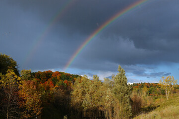 Fototapeta na wymiar Double rainbow over fall Landscape with rain