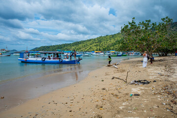 A Paradise island, tropical beach, emerald green sea with beach trees and blue sky background, Indonesia, south asia. Local people have a simple life like fishermen and sellers. Indonesia, South Asia.