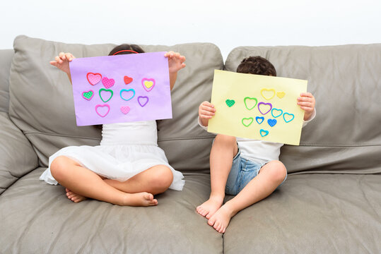 Children Holding Hand Made Gift Card With Love Heart Shape.