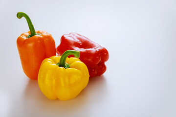 Red, orange and yellow bell peppers isolated on white background.