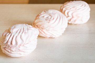 three light pink candy on the table.