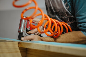 Closeup shot of a carpenter using an industrial stapler